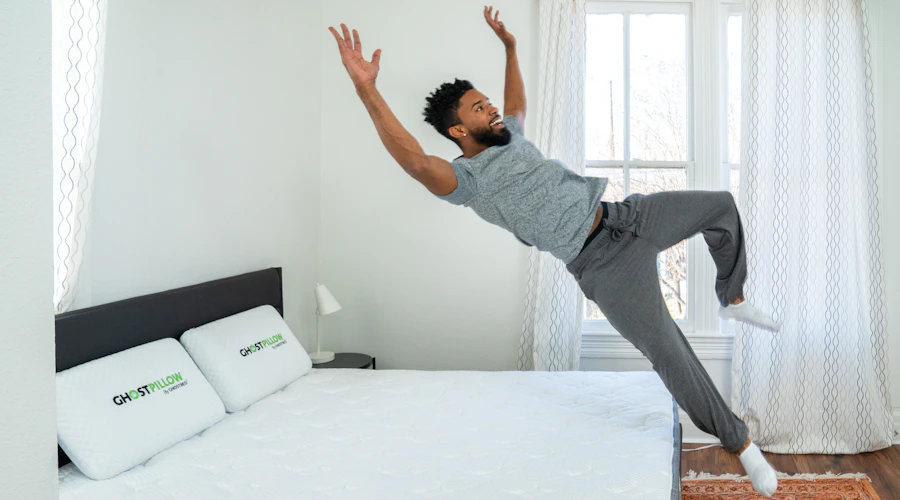 Man jumping backwards into bed