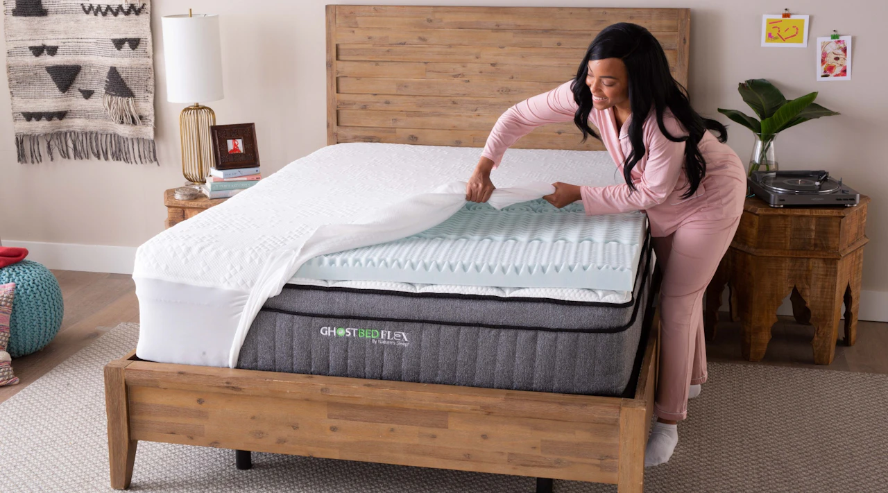 Woman adding a waterproof cover on top of a mattress topper