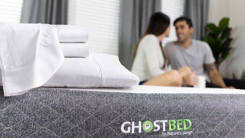 Couple relaxing on their GhostBed mattress with luxury Supima cotton & TENCEL™ GhostSheets.