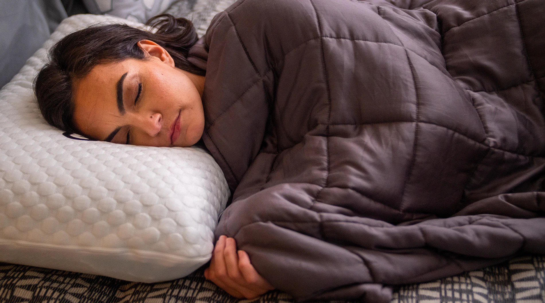 Woman sleeping on side under weighted blanket