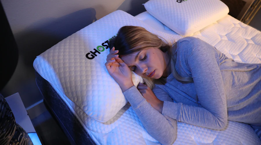 A woman tries to get comfortable on her GhostBed Mattress and GhostPillow.