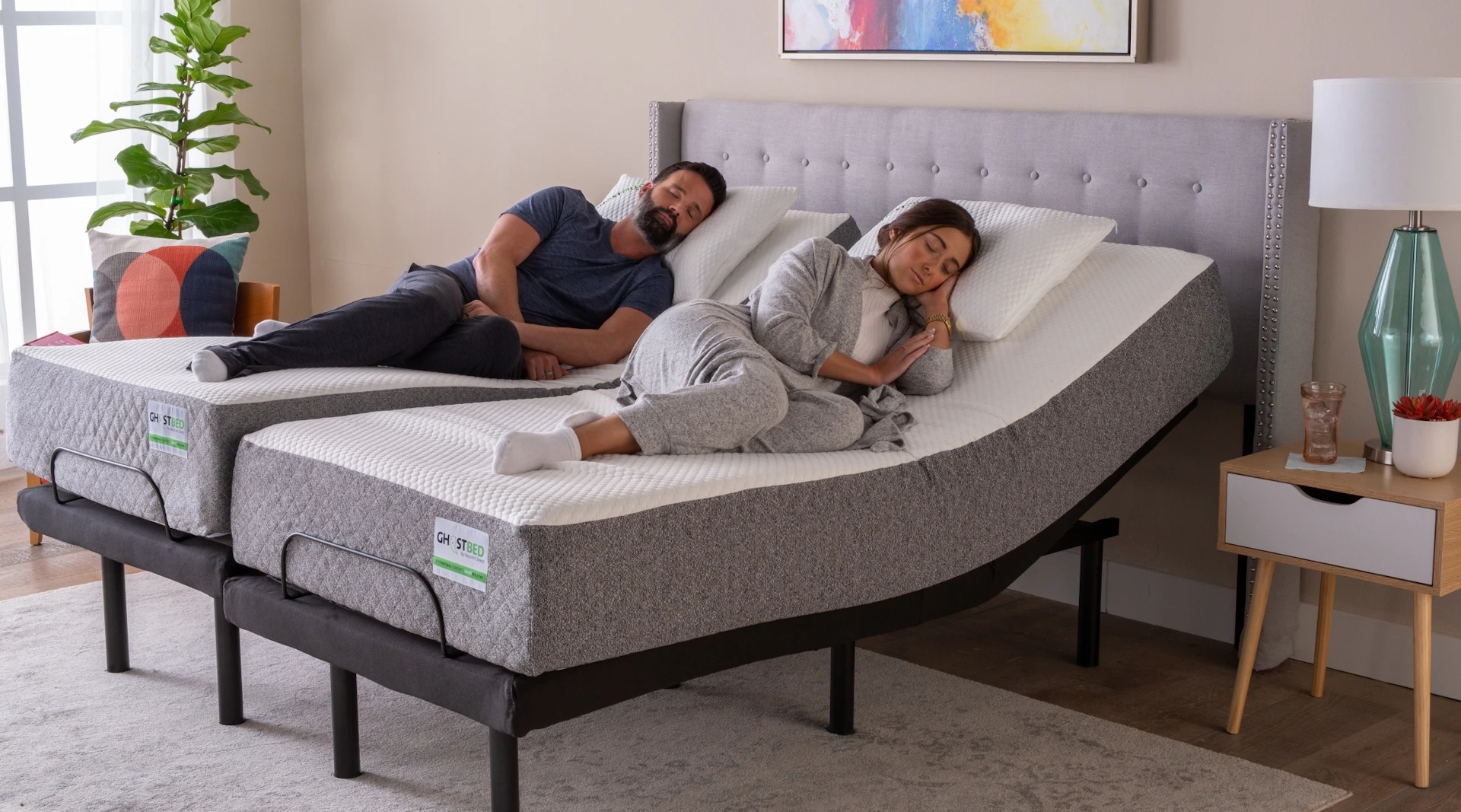 A couple enjoying the benefits of the GhostBed Split King Adjustable Bed Base.